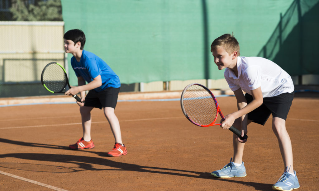 Spécialiste ski tennis Toulouse. Deux joueurs de tennis sur terre battue côte à côte position d'attention.